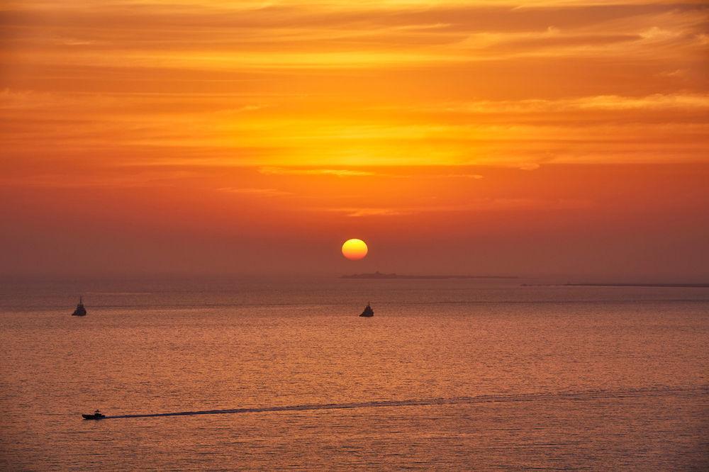 Four Seasons Hotel Ad Dawhah Esterno foto Sunset over the Gulf of Naples